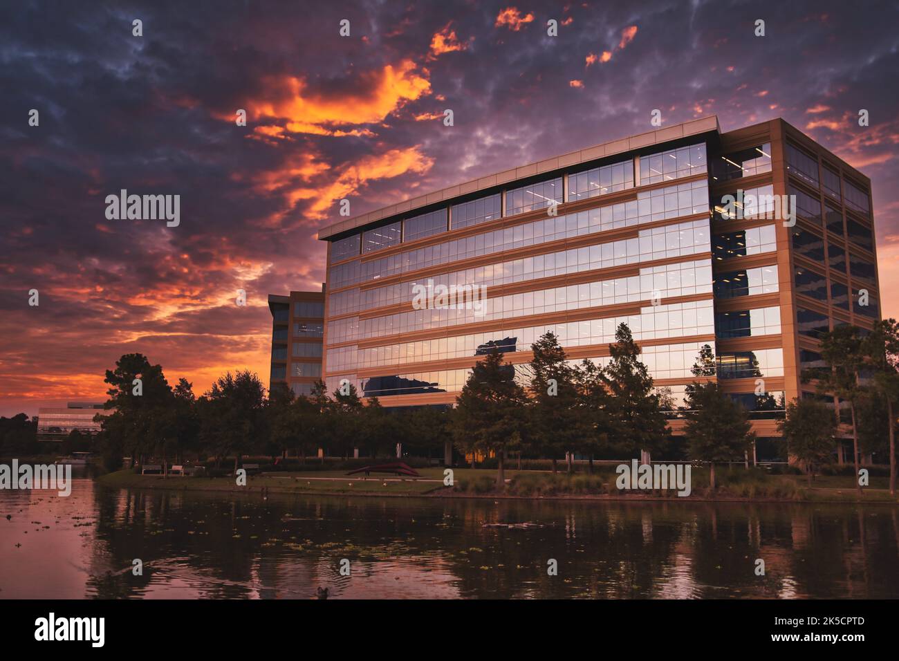 A photo of a commercial office building under a sunset sky on Lake