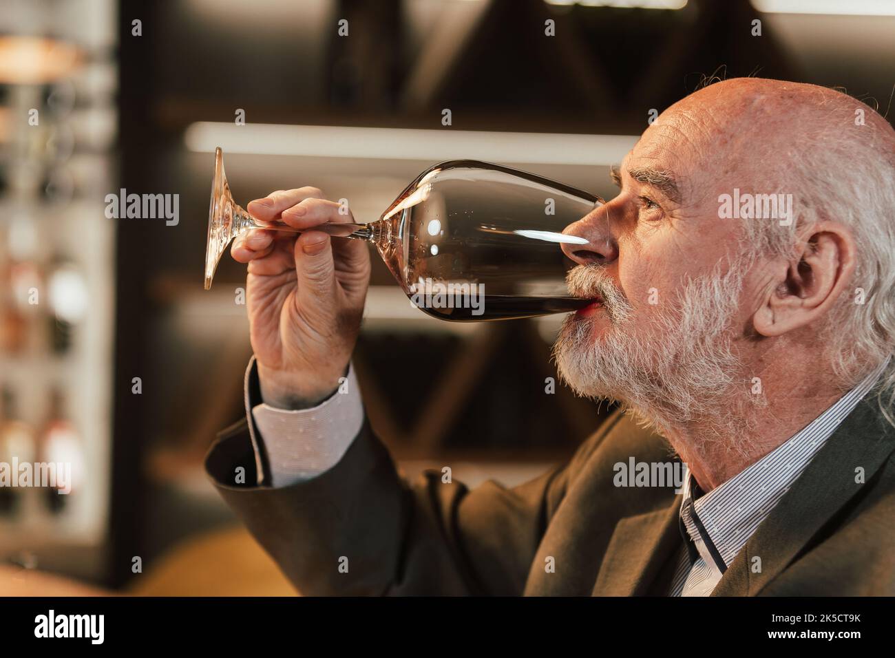 People drinking wine and eating cold cut meat in a wine cellar. Stock Photo