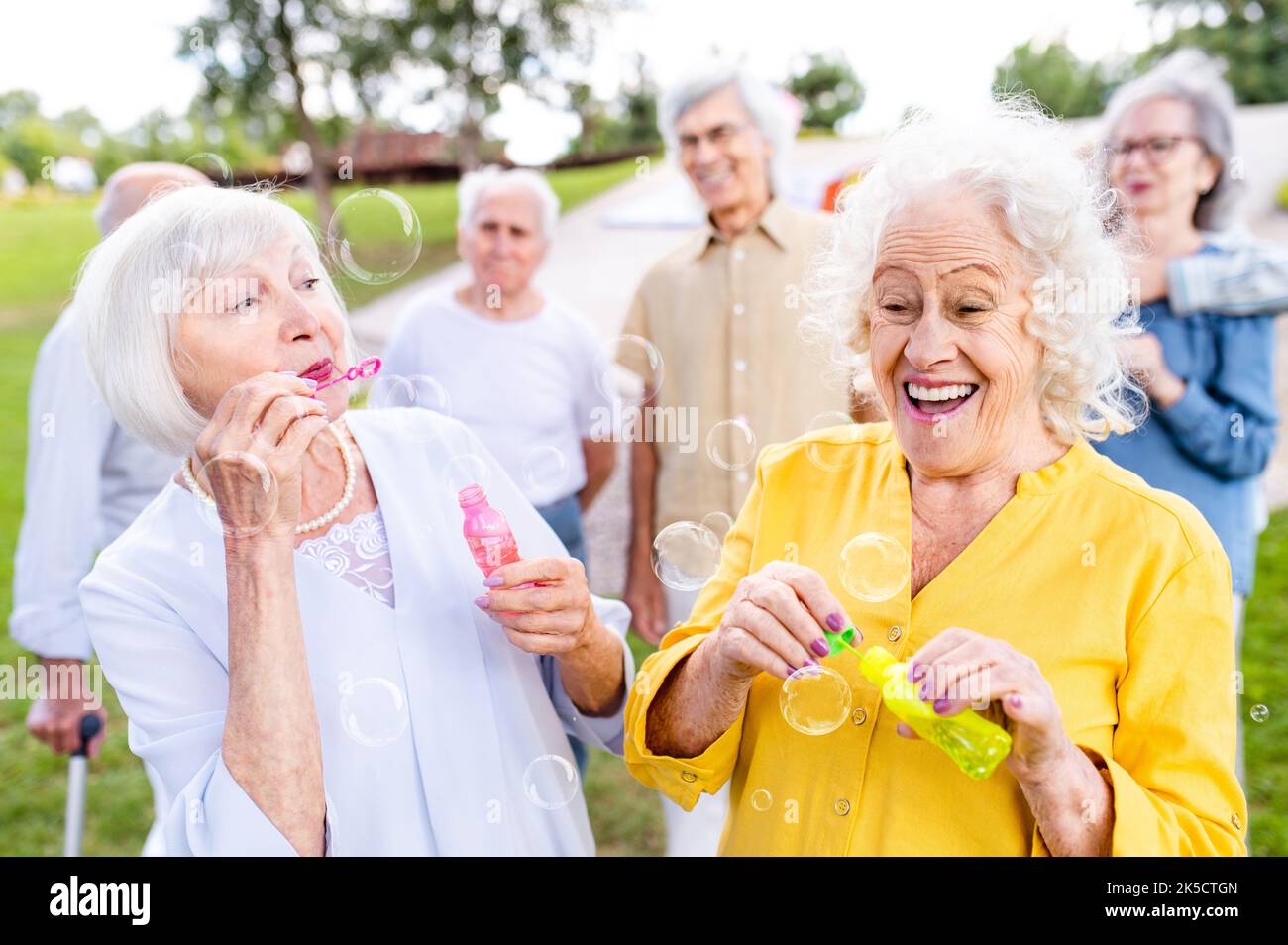 Group of happy elderly people bonding outdoors at the park - Old people