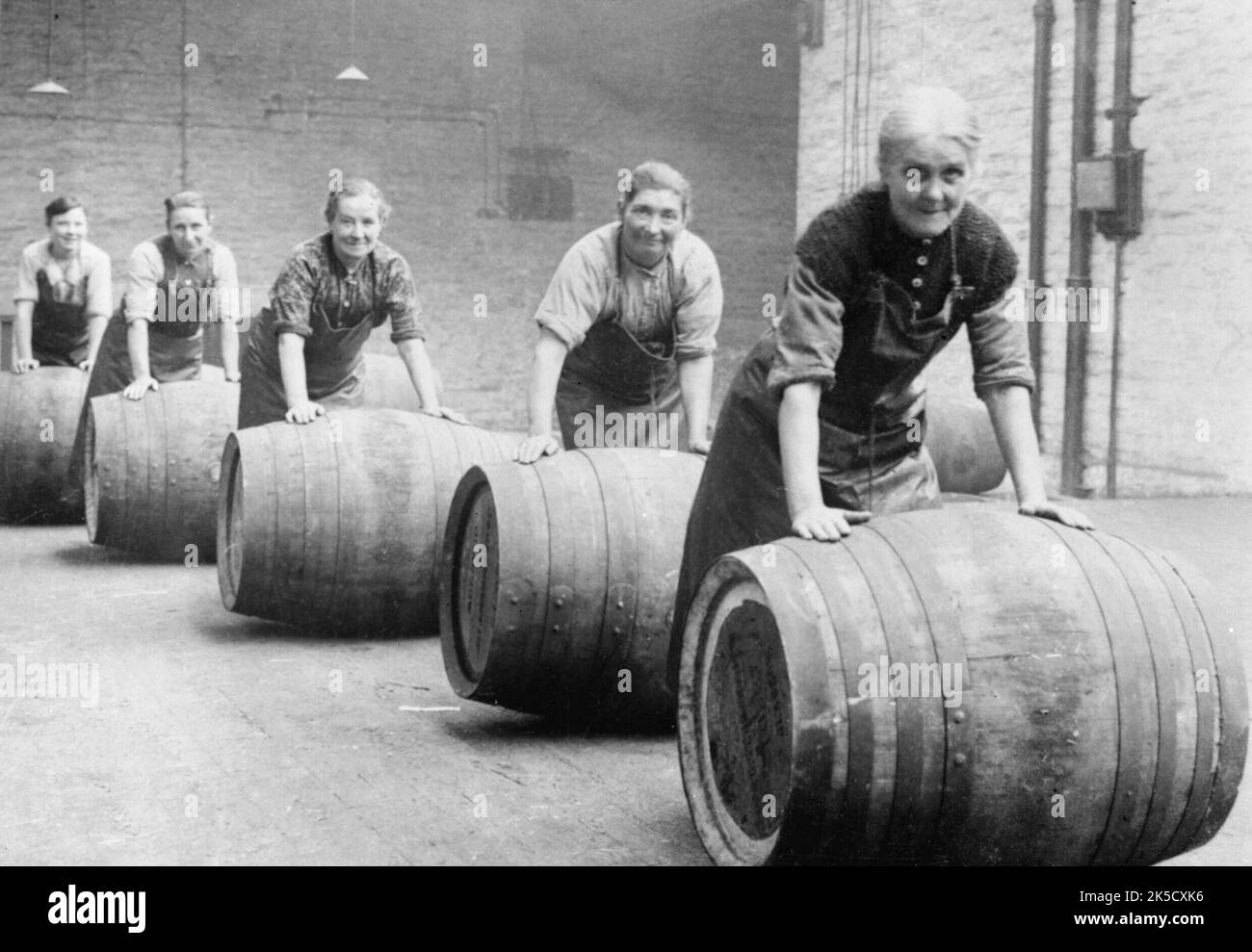 The Employment of Women in Britain, 1914-1918 Female workers roll casks of beer across the floor at a brewery in Cheshire, September 1918. Stock Photo