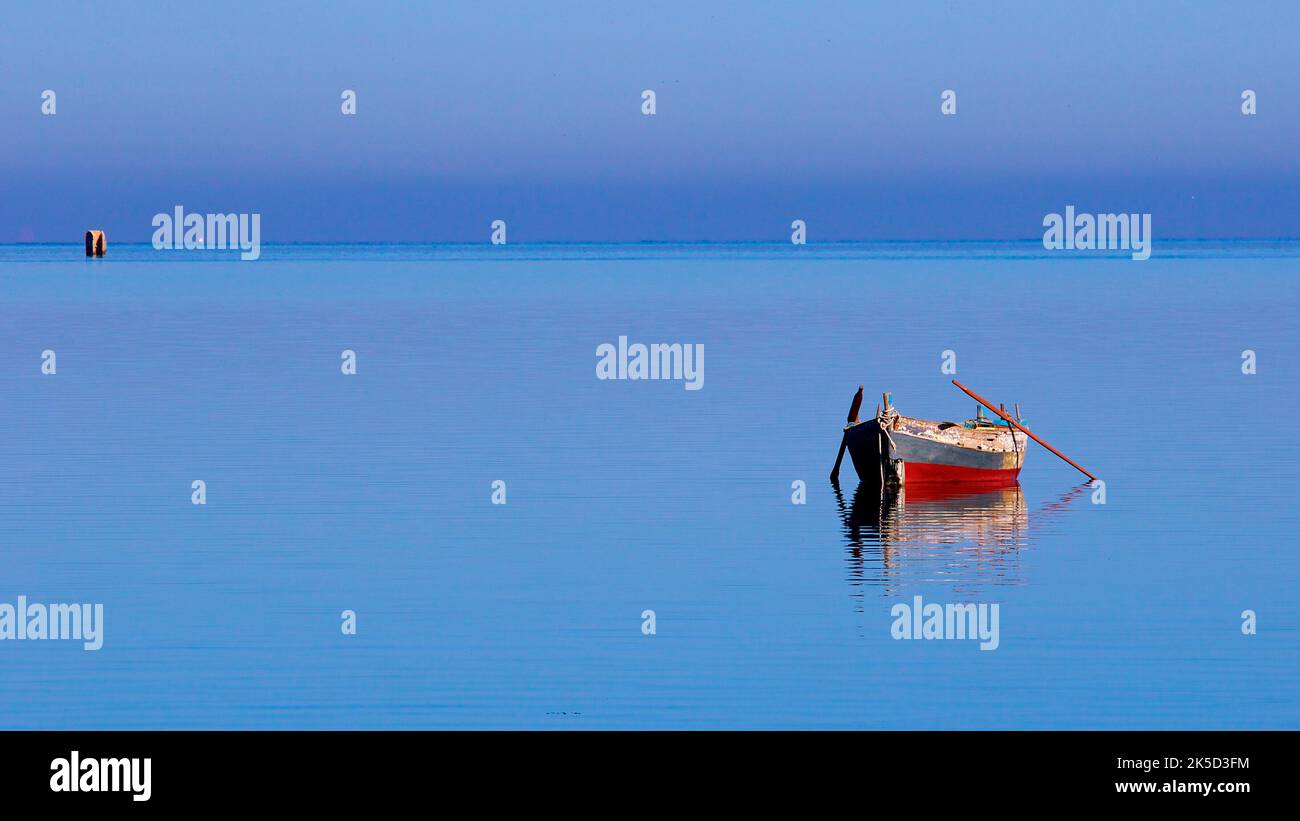 Italy, Sicily, west coast, Marsala, fisherman, fishing boat, fish market, very calm blue sea, single rowboat without people Stock Photo