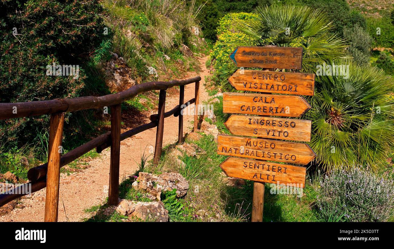 Italy, Sicily, Zingaro National Park, spring, hiking trail, wooden railing, wooden signposts, palm trees Stock Photo