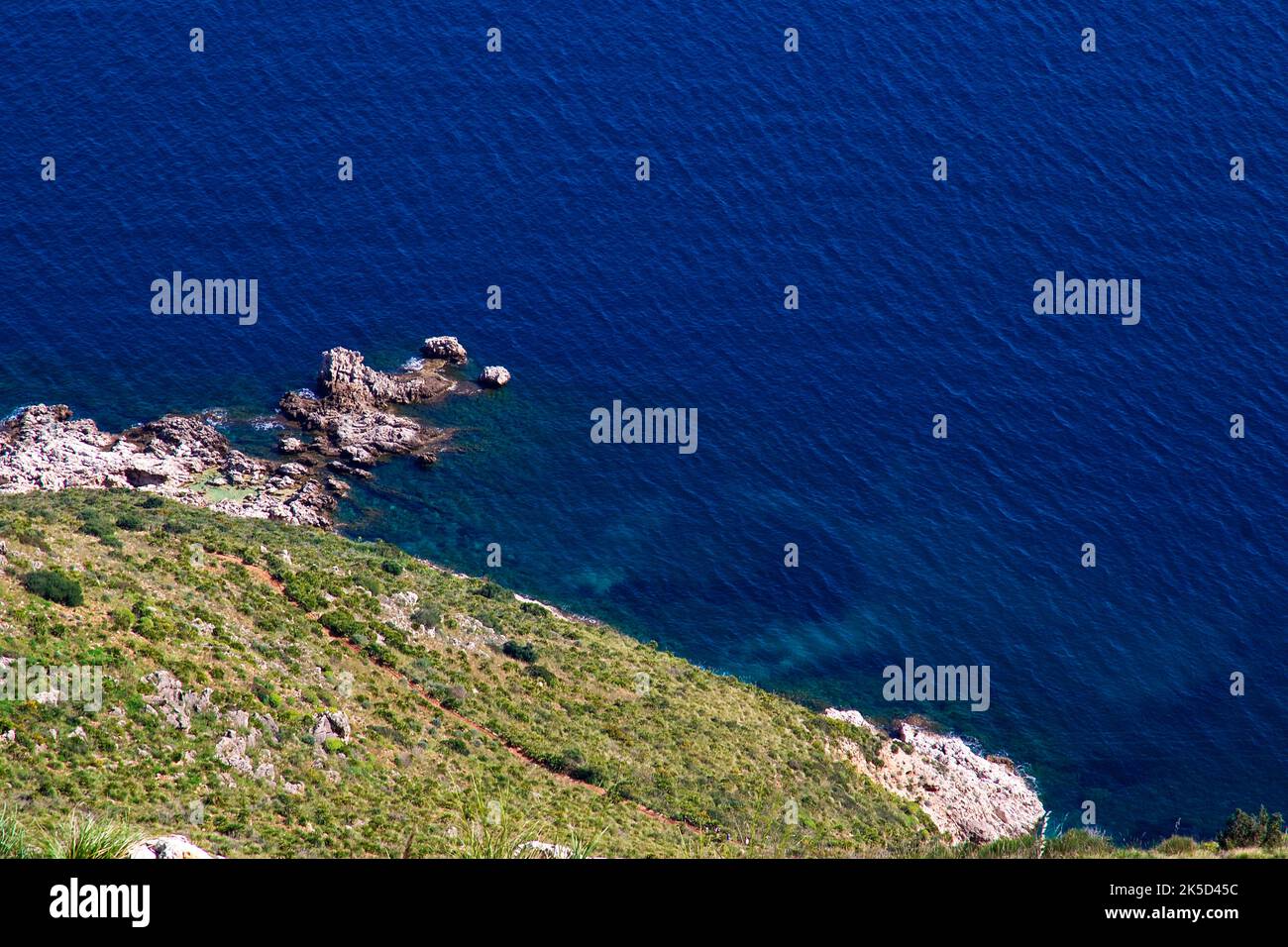 Italy, Sicily, Zingaro National Park, spring, view down to the coast, green-yellow vegetation, rocks in the sea Stock Photo