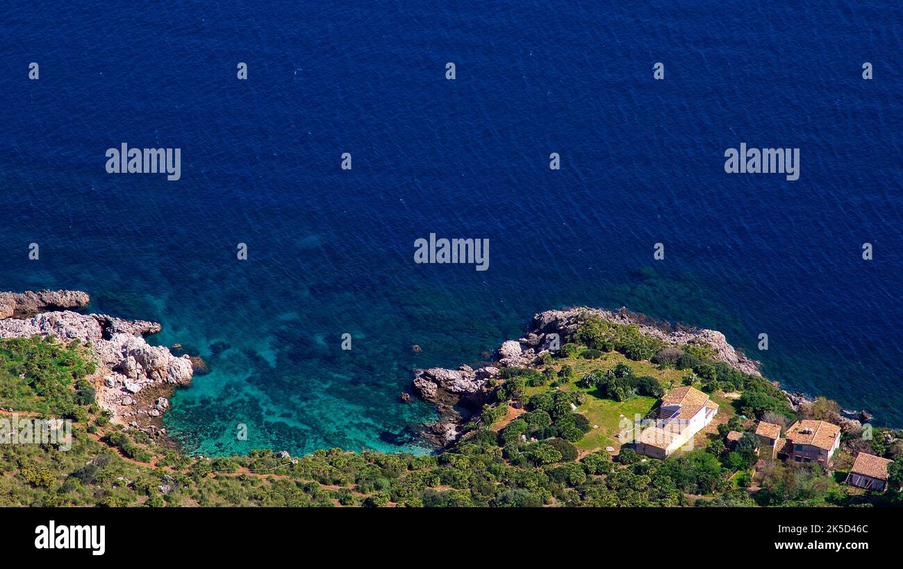 Italy, Sicily, Zingaro National Park, spring, view down to the coast, bay, sea green, blue sea, houses with red tiled roofs Stock Photo