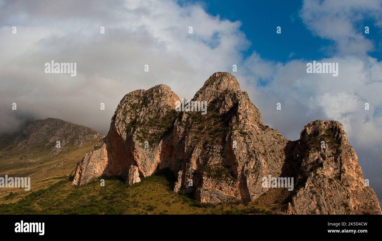 Italy, Sicily, mountains, three peaks, Macari mountains, blue sky with dense white clouds, soft light Stock Photo