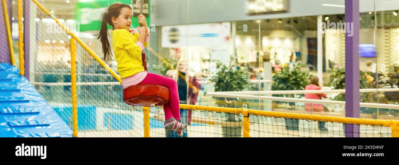 Child jumping on colorful playground trampoline. Kids jump in inflatable bounce castle on
