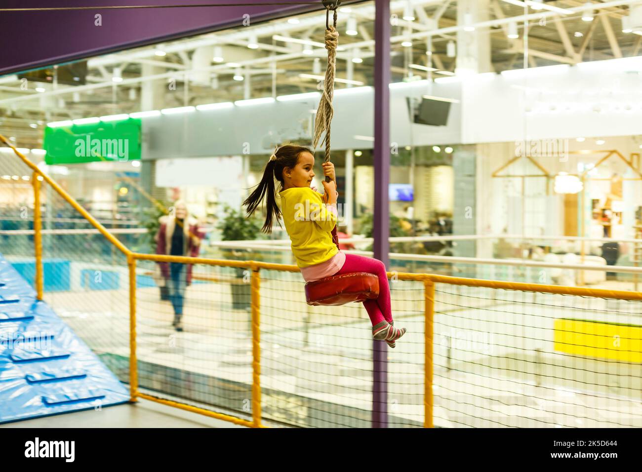 Adorable Little girl laughing happily, riding upside down on a bungee ...