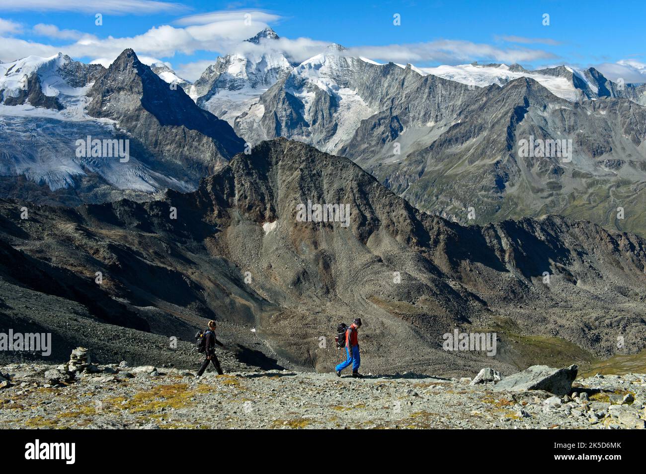 Mountain hikers in front of the chain of peaks of the Valais Alps, peaks from left to right Blanc de Moming, Besso, Dent Blanche, Grand Cornier, Zinal, Val d'Anniviers, Valais, Switzerland Stock Photo