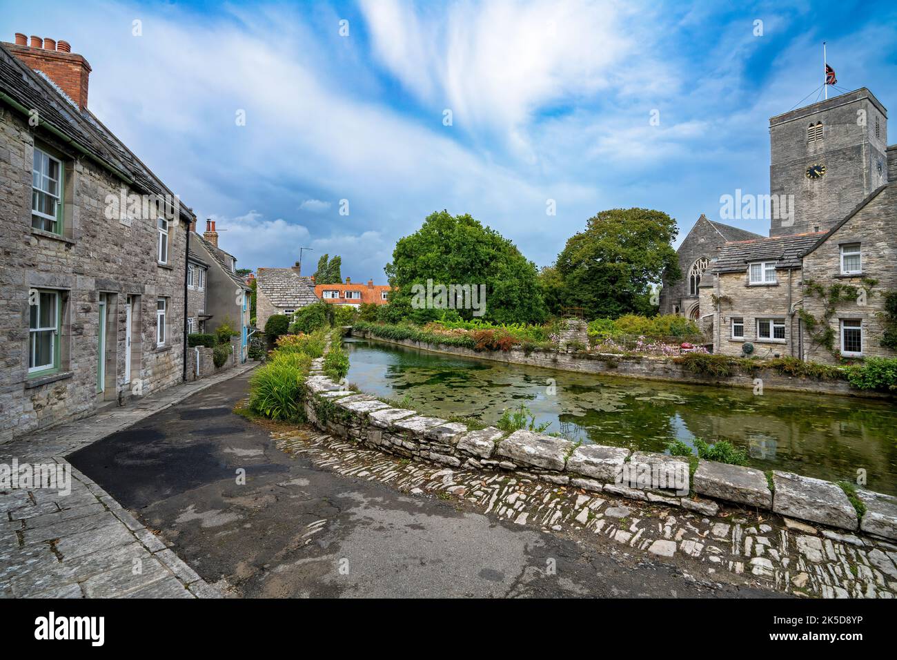 Mill pond, cottages and the Church of St Mary the Virgin on a summer day at Swanage, Dorset, UK Stock Photo