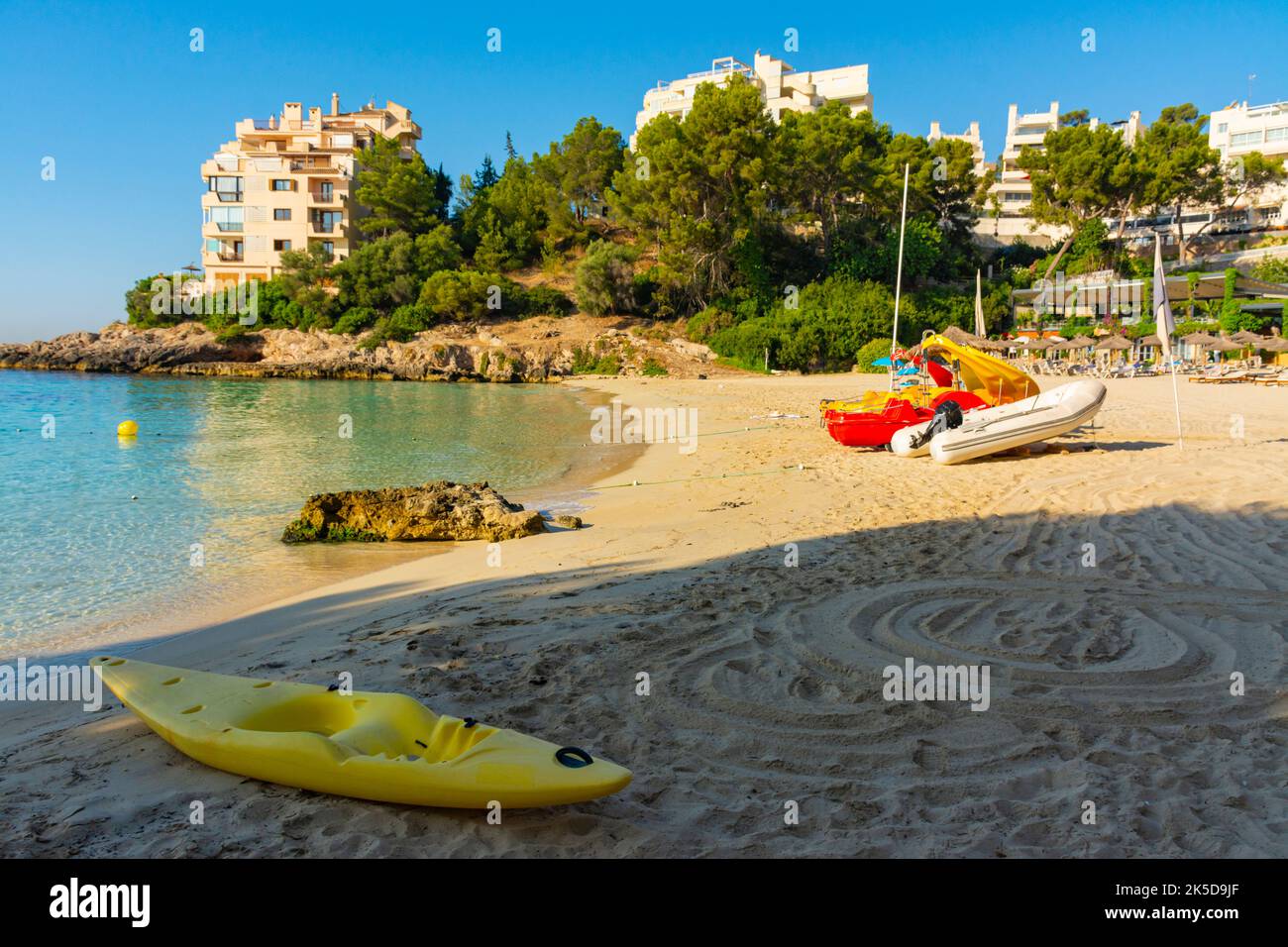 Plastic yellow canoe, dinghy and pedal boats, on the sandy beach, at
