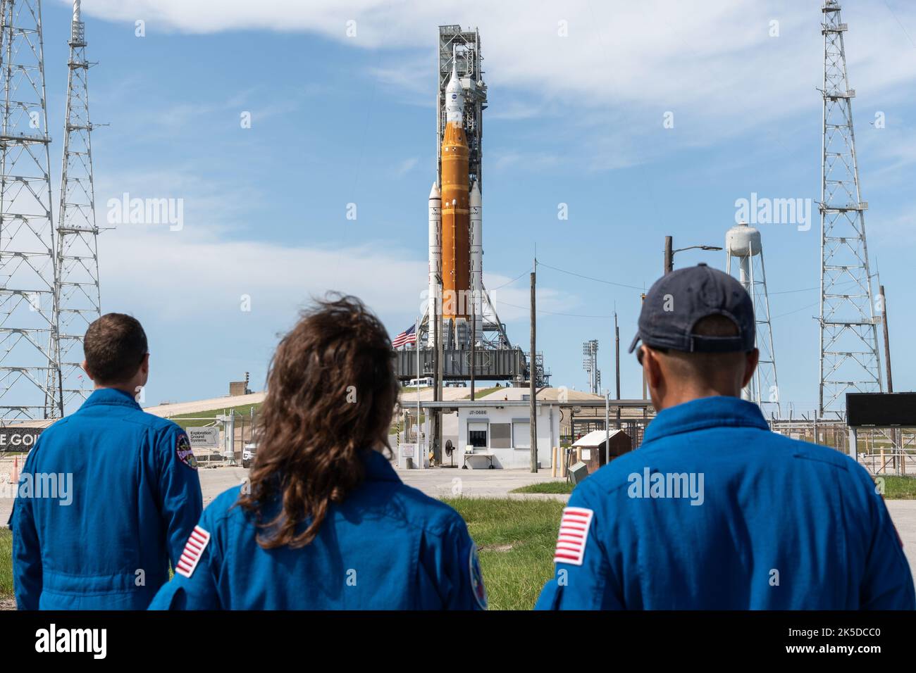 From left to right, NASA Astronauts Reid Wiseman, Christina Koch, and Joe Acaba view the Space Launch System and Orion spacecraft on Launch Pad 39B. They arrived via T-38 jet to support various pre-launch activities. Stock Photo