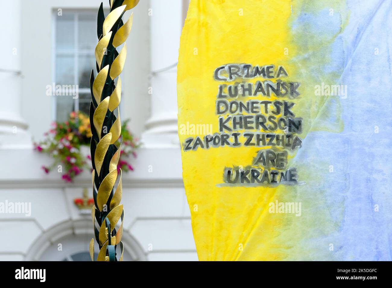 Ukranian flag with a list of provinces that belong to Ukraine not Russia in Cheltenham UK October 2022 Stock Photo