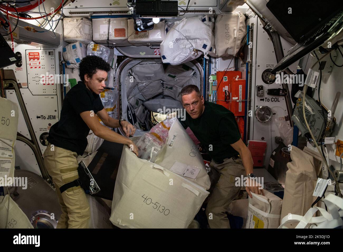 Expedition 67 Flight Engineers Jessica Watkins and Bob Hines, both from NASA, unload cargo and time-critical science experiments a couple of hours after the SpaceX Dragon resupply ship docked to the Harmony module's forward port on the International Space Station. Stock Photo