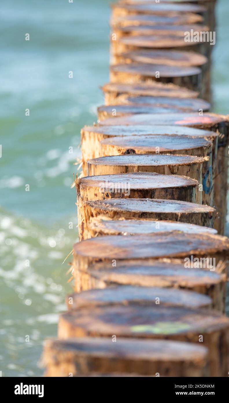 Wooden breakwater and rough sea. Waves at sea crash against the wooden