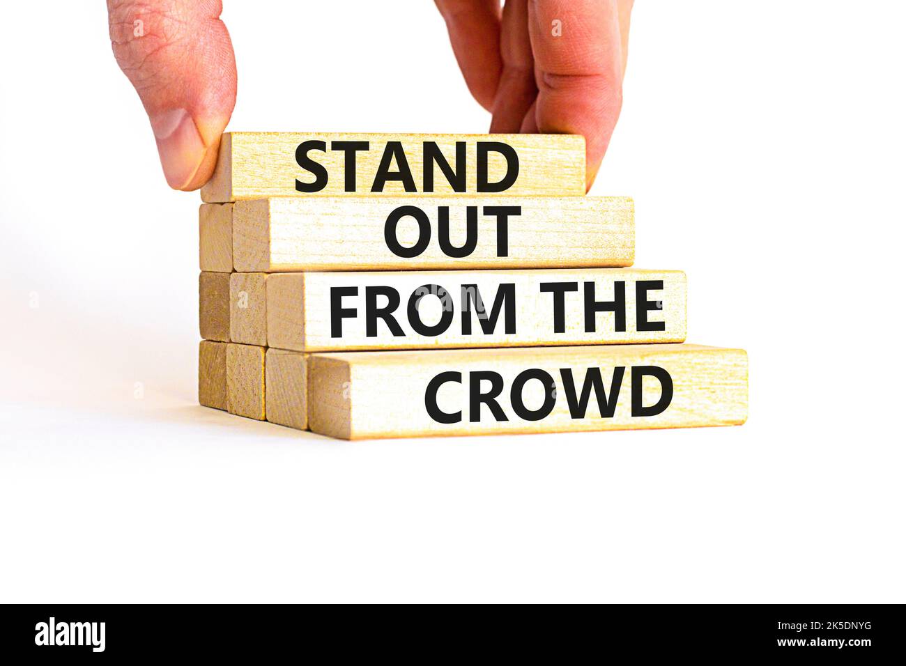 Stand out from the crowd symbol. Concept words Stand out from the crowd on wooden blocks on