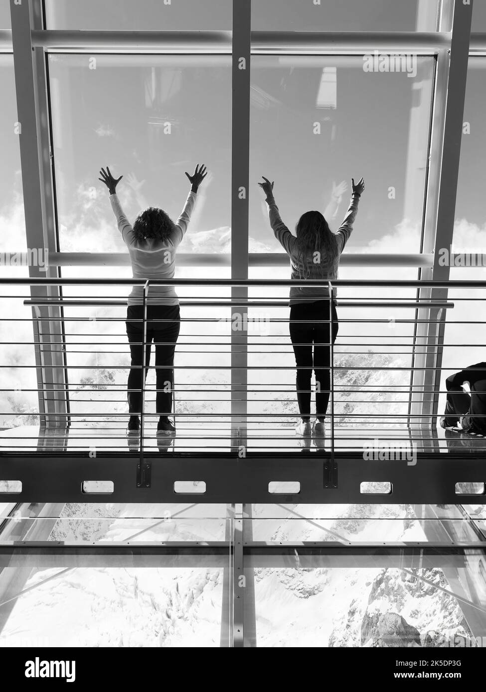 Two ladies put their hands in the air at a viewpoint at the top of