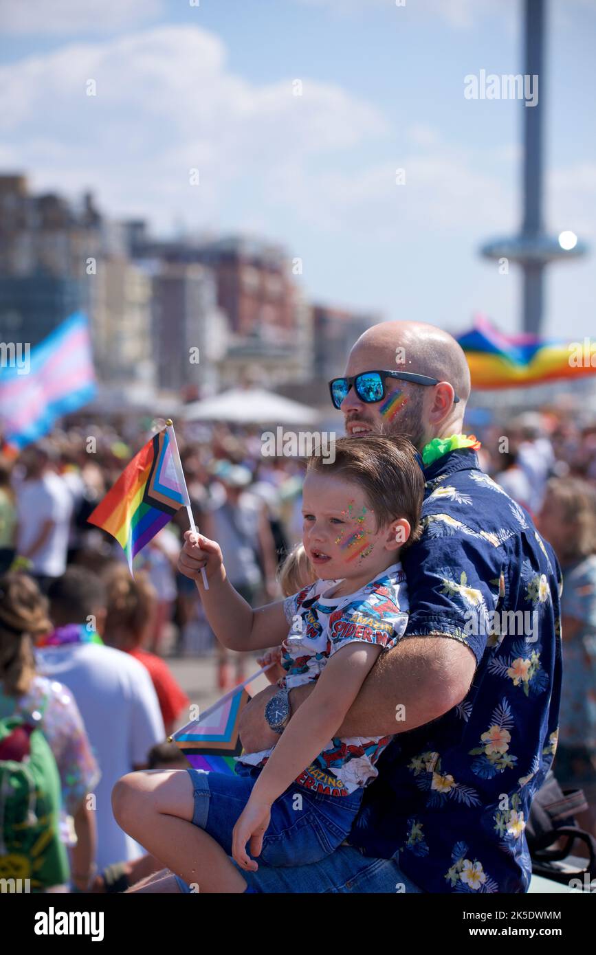 Brighton & Hove Pride Festival, Brighton & Hove, East Sussex, England. Father and son watching the passing parade. Stock Photo