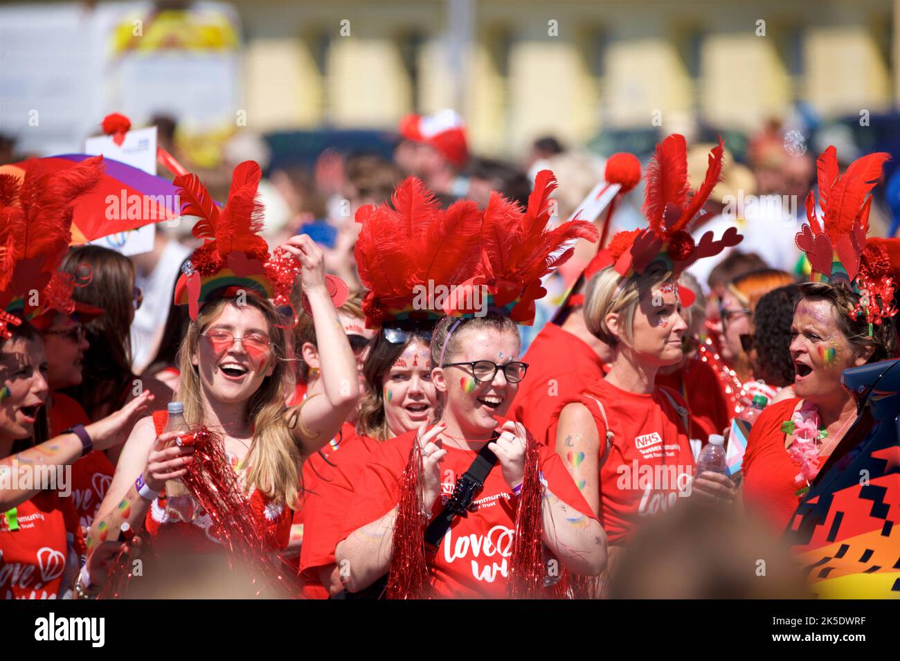 Brighton & Hove Pride Festival, Brighton & Hove, East Sussex, England. Women dressed in red participating in the parade, smiling and happy. Stock Photo