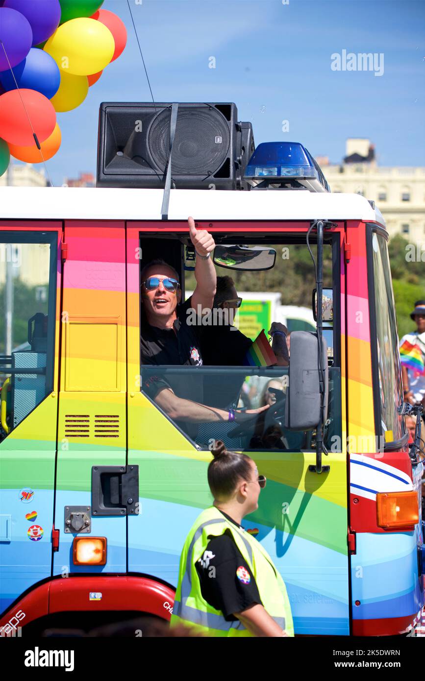 Brighton & Hove Pride Festival, Brighton & Hove, East Sussex, England. Thumbs up from a Fireman driving a decorated Fire truck. Stock Photo