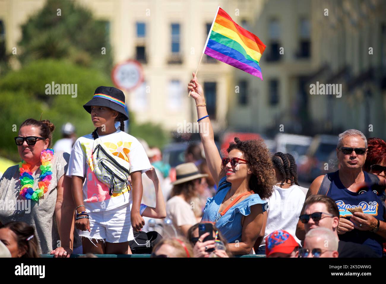 Brighton & Hove Pride Festival, Brighton & Hove, East Sussex, England. Spectator waving rainbow flag Stock Photo