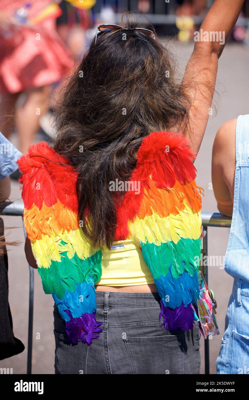 Brighton & Hove Pride Festival, Brighton & Hove, East Sussex, England. Spectator wearing angel wings in rainbow colours. Stock Photo