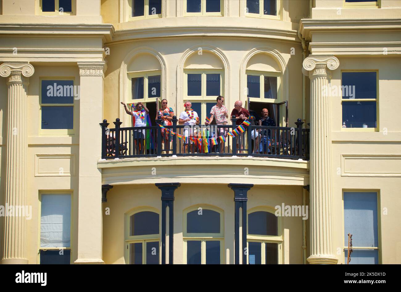 Brighton & Hove Pride Festival, Brighton & Hove, East Sussex, England. Locals looking on from the Regency architecture of Brunswick Terrace, Hove. Stock Photo