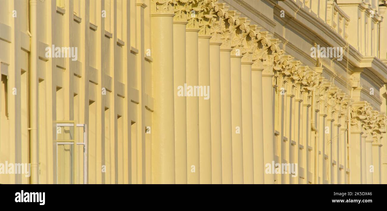 Freshly painted Corinthian columns of Brunswick Terrace, part of a complex of Regency houses in Hove on Brighton and Hove seafront. East Sussex, England UK. A single window open. Stock Photo