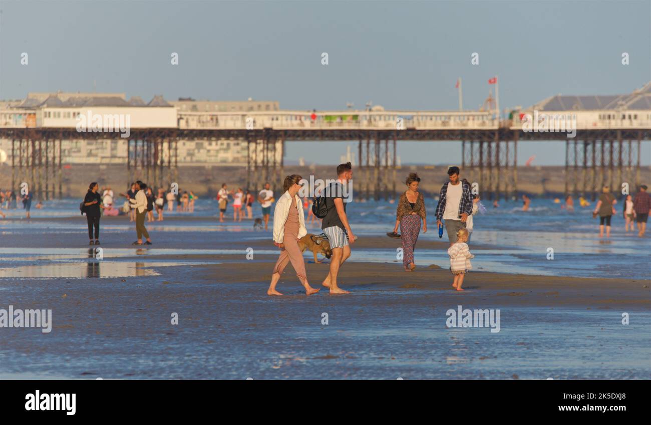 People on the beach at low tide in the late afternoon, July, Brighton & Hove, East Sussex, England, UK. Stock Photo