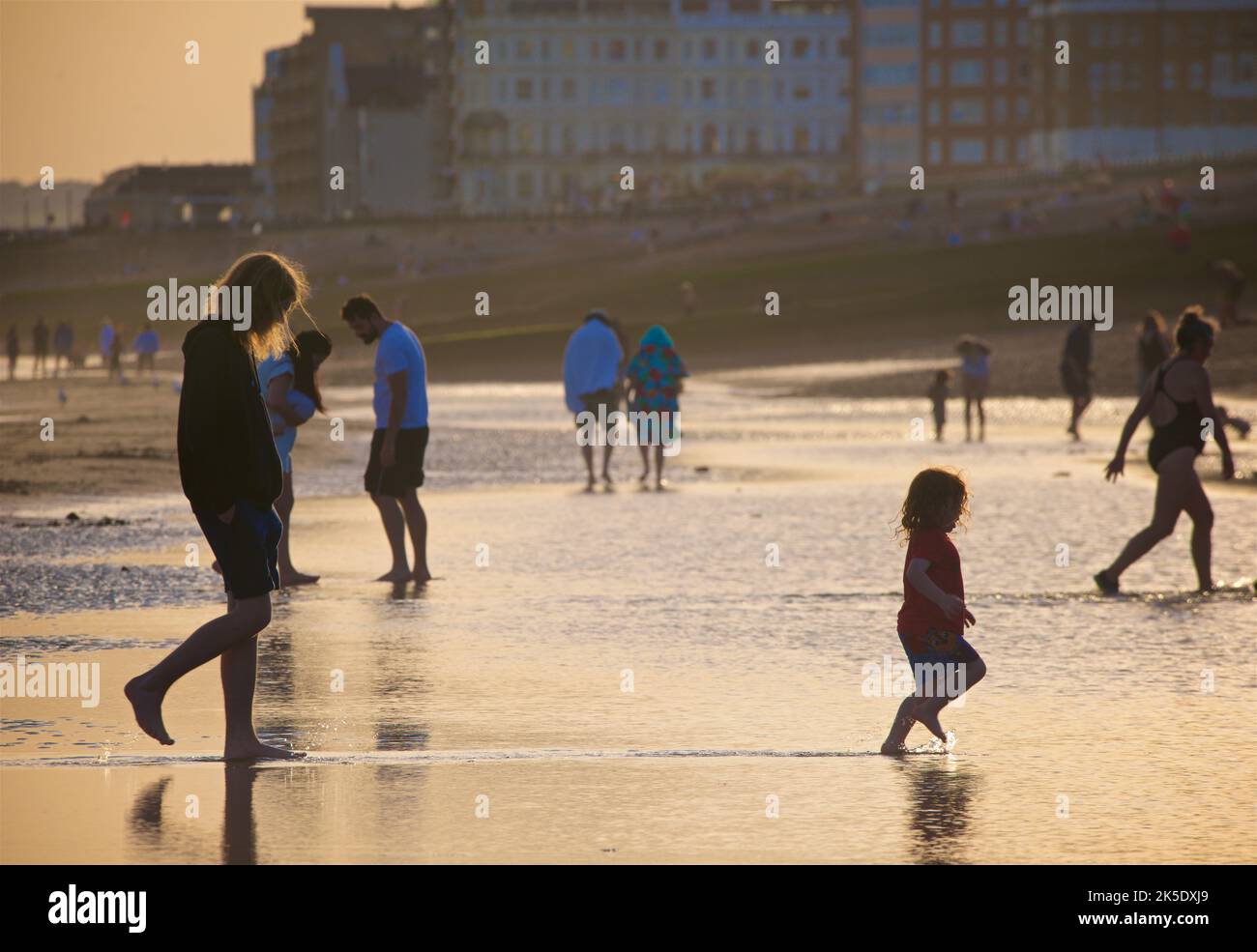 People on the beach at low tide in the late afternoon, July, Brighton & Hove, East Sussex, England, UK. Stock Photo