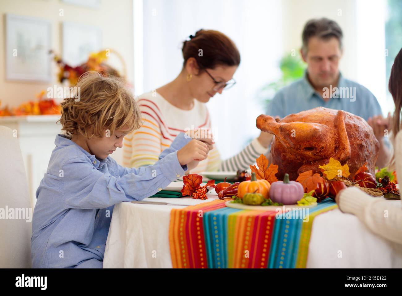 Family Thanksgiving dinner prayer. Parents and kids enjoy roasted