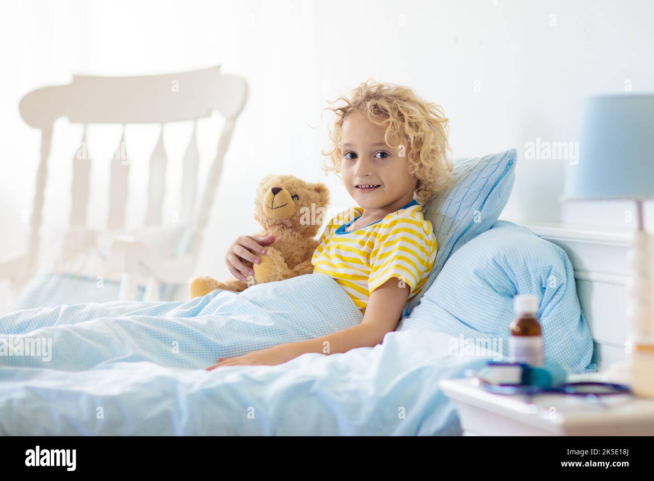 Sick little boy with asthma medicine. Ill child lying in bed. Unwell