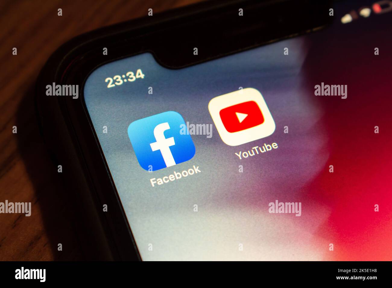 Vancouver, CANADA - Oct 6 2022 : Facebook and YouTube icons on an iPhone screen on wooden table. Stock Photo