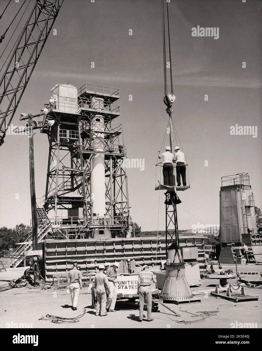 This historical photograph shows the installation of a Mercury capsule and escape system on the top of booster prior to test firing of Mercury-Redstone at the Redstone test stand at the Marshall Space Flight Center (MSFC). 1960. Assembled by MSFC, Mercury-Redstone was designed to place a manned space capsule in orbital flight around the earth and recover both safely. The MSFC, located in Redstone Arsenal, Alabama, is the U.S. government's civilian rocketry and spacecraft propulsion research center. An optimised version of an original NASA image. Credit: NASA Stock Photo