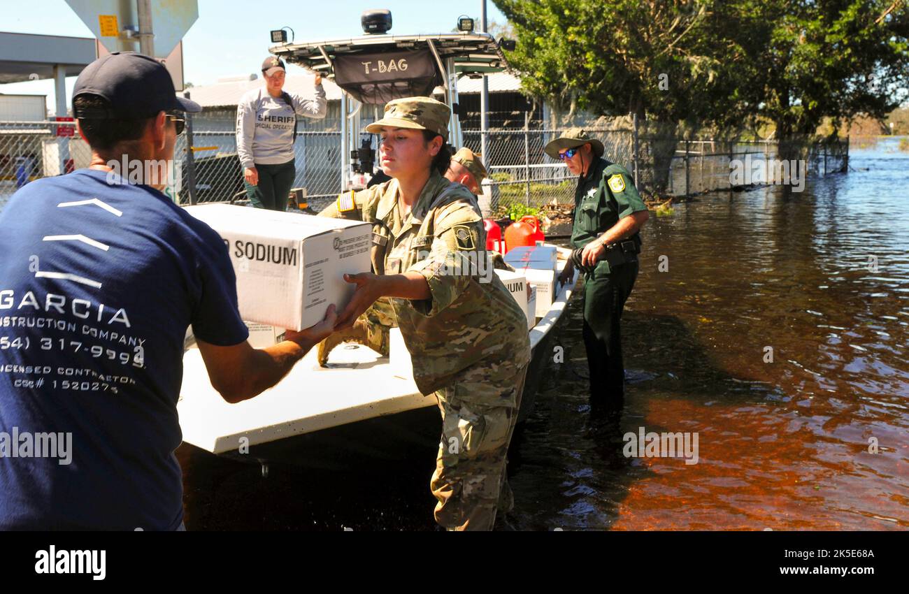 Florida Army National Guard Spc. Karina Huari assigned to Detachment 1, Headquarters and Headquarters Battery, 2nd Battalion, 116th Field Artillery Regiment assists law enforcement and residents load rescue boats with supplies during emergency response efforts from Hurricane Ian in Arcadia Florida 2, Oct. 2022. These boats carried food, water and supplies to a point of distribution (POD) approximately 2 miles across a flooded zone where residents before could not access. (Florida Army National Guard photo credit by Staff Sgt. Cassandra Vieira) Stock Photo