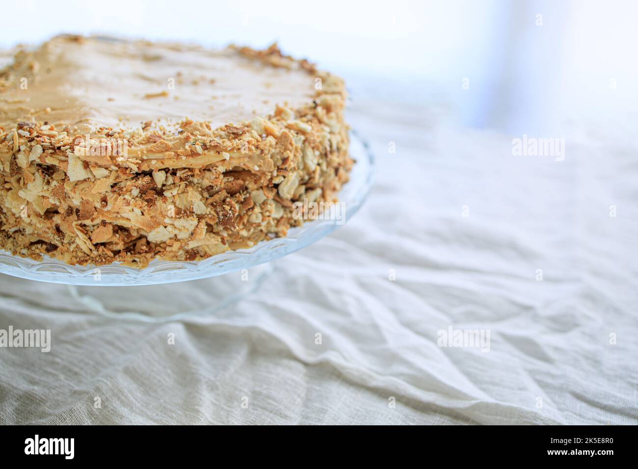 napoleon cake, round whole with caramel cream on a white background. copy space. Stock Photo