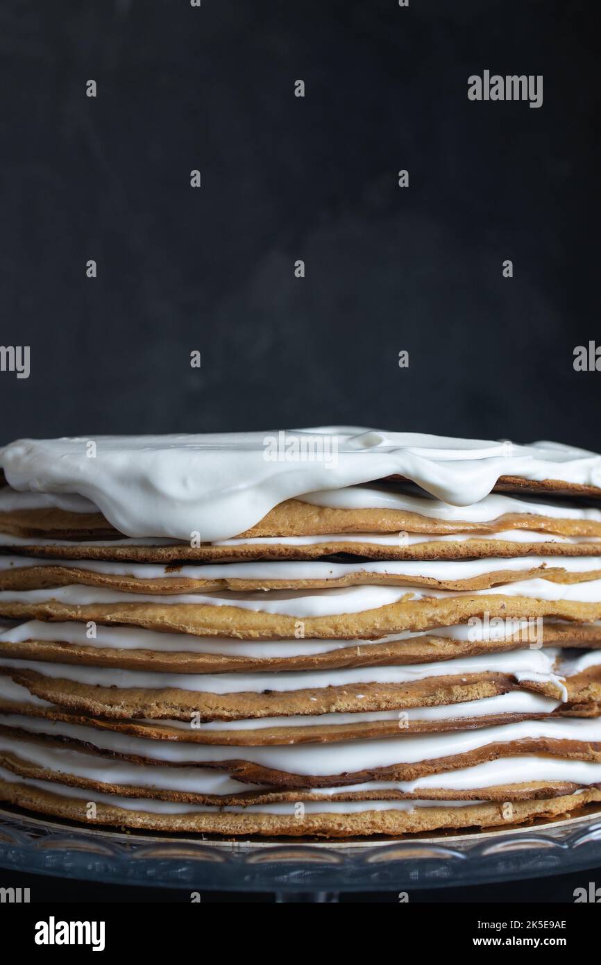 a whole round honey cake on a stand against a dark background. Stock Photo
