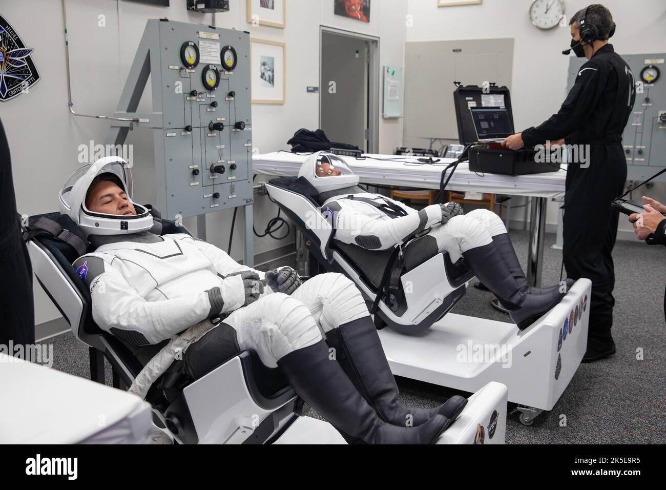 Crew-4 mission astronauts Kjell Lindgren, left, and Bob Hines relax in the suit room in the Astronaut Crew Quarters inside Kennedy Space Center’s Neil A. Armstrong Operations and Checkout Building on April 27, 2022. A team of SpaceX suit technicians assisted the crew as they put on their custom-fitted spacesuits and checked the suits for leaks. Astronauts Jessica Watkins and Samantha Cristoforetti will join Lindgren and Hines aboard SpaceX’s Crew Dragon, powered by the company’s Falcon 9 rocket, which will carry the four-person crew to the International Space Station as part of NASA’s Commerci Stock Photo