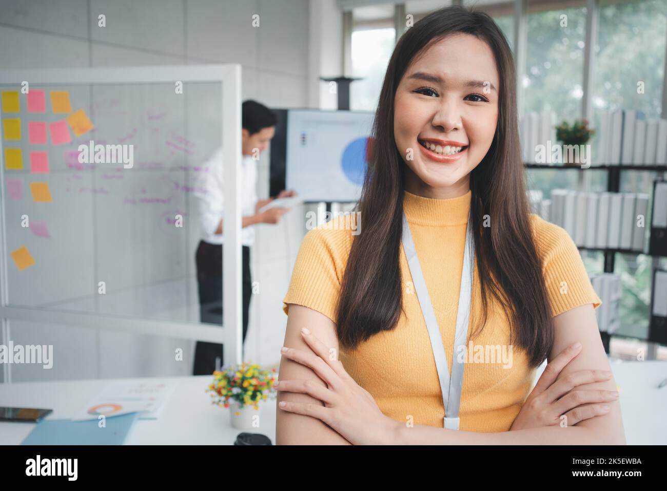 Young Asian Happy Businesswoman or intern in Modern Office background is Colleagues discuss with new startup project Idea. Empowered Digital Entrepren Stock Photo