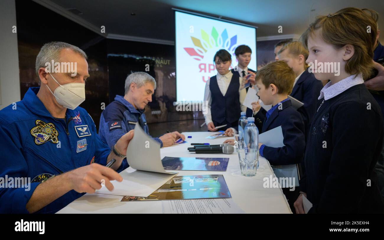 NASA Astronaut Office Representative, astronaut Drew Feustel, left, and Roscosmos Executive director of Human Spaceflight Programs Sergei Krikalev, give autographs to children from a local school, Monday, March 28, 2022, at the Cosmonaut Hotel in Karaganda, Kazakhstan. The two were part of an earlier meeting where NASA, Roscosmos, and Russian Search and Recovery Forces meet to discuss the readiness for the landing of Expedition 66 crew members Mark Vande Hei of NASA, and Pyotr Dubrov, and Anton Shkaplerov of Roscosmos. Vande Hei and Dubrov will be returning to Earth after logging 355 days in s Stock Photo