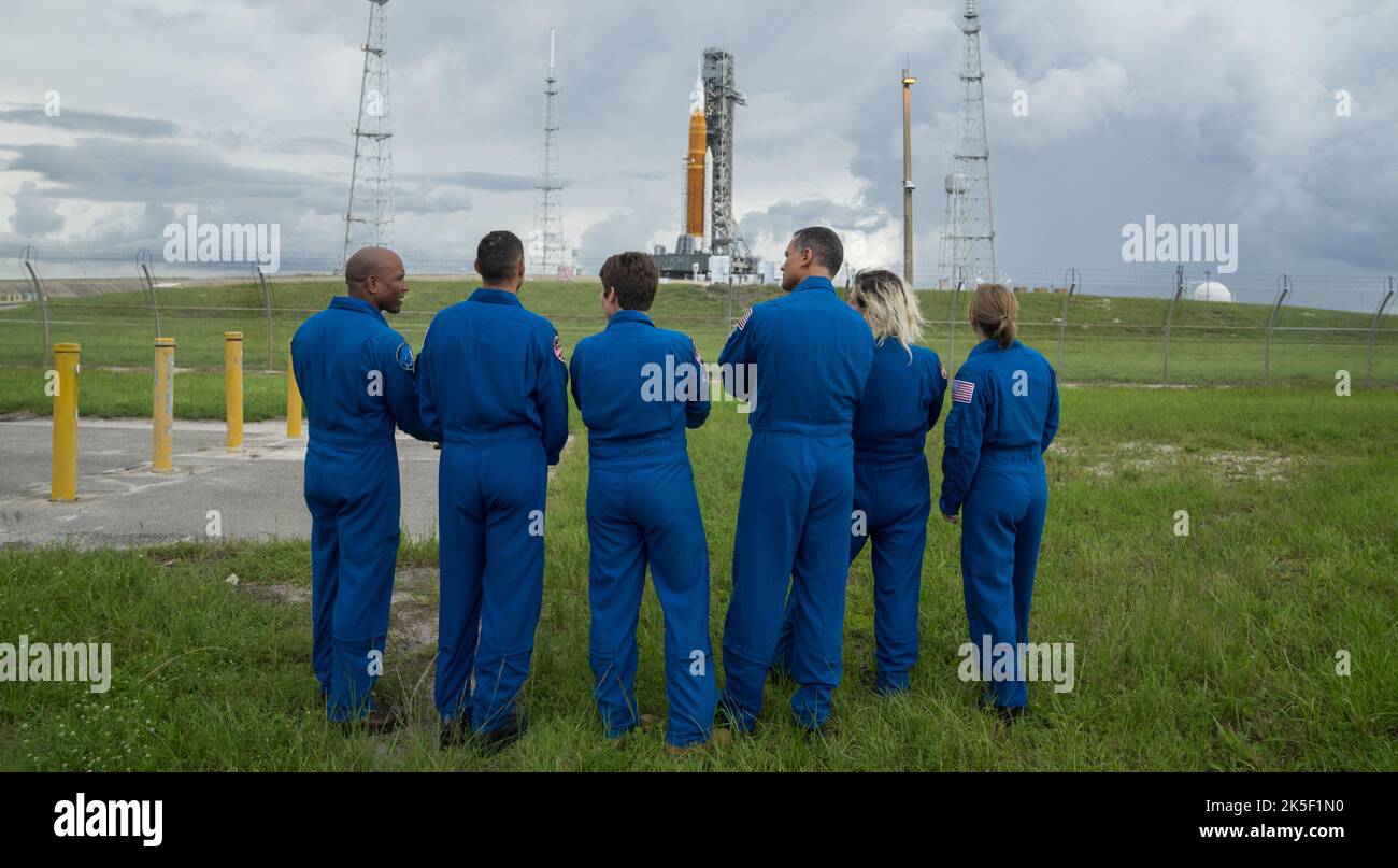 NASA astronauts and astronaut candidates view NASA’s Artemis I Space Launch System and Orion spacecraft atop the mobile launcher on the pad at Launch Complex 39B at the agency’s Kennedy Space Center in Florida on Sept. 2, 2022. The astronauts are, from left to right: Victor Glover, NASA astronaut; Marcos Berrios, NASA astronaut candidate; Anne McClain, NASA astronaut; Anil Menon and Deniz Burnham, NASA astronaut candidates; and Zena Cardman, NASA astronaut. The first in a series of increasingly complex missions, Artemis I will provide a foundation for human deep space exploration and demonstra Stock Photo