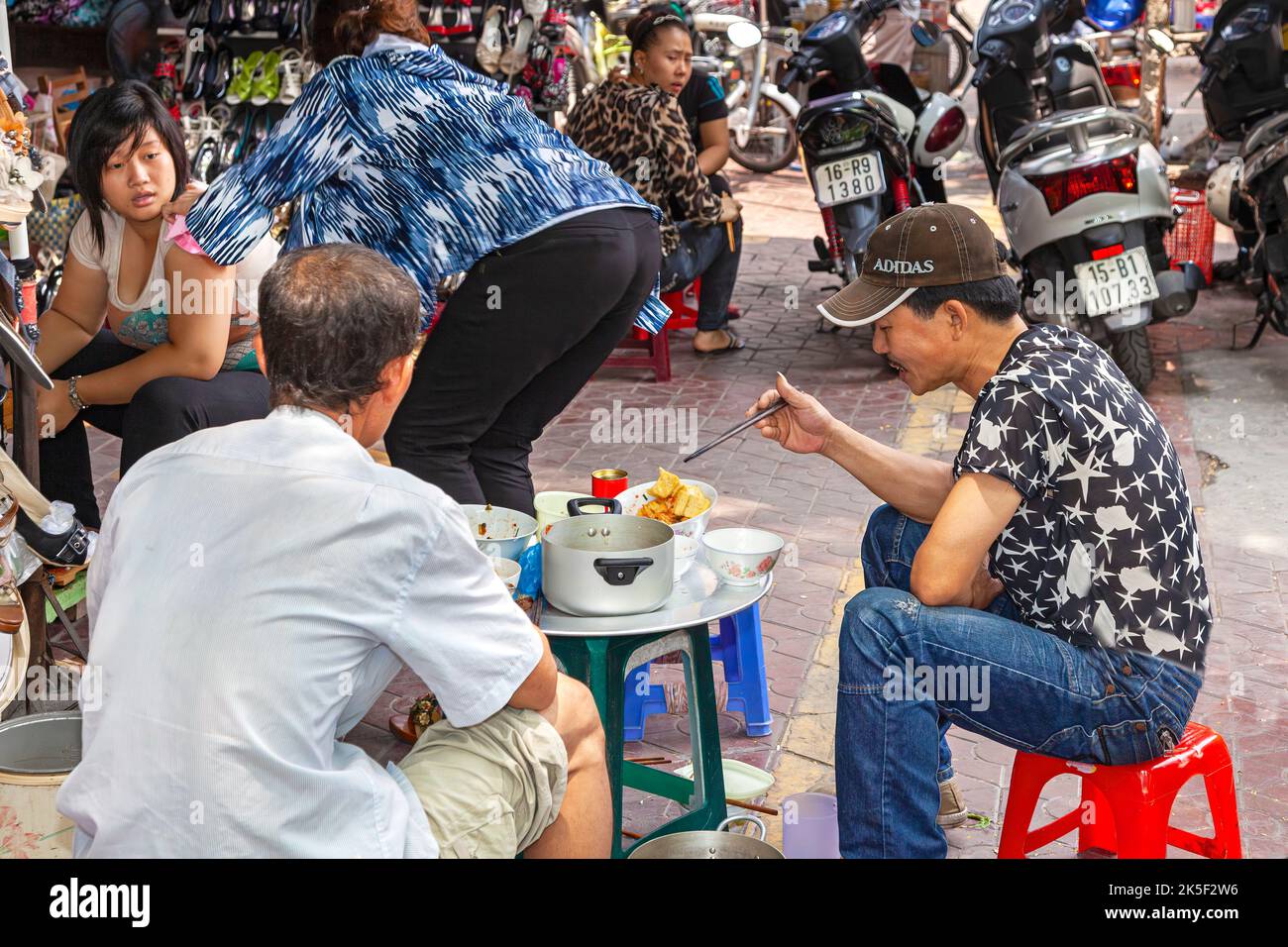 Vietnamese people eating at open air street restaurant, Hai Phong, Vietnam Stock Photo