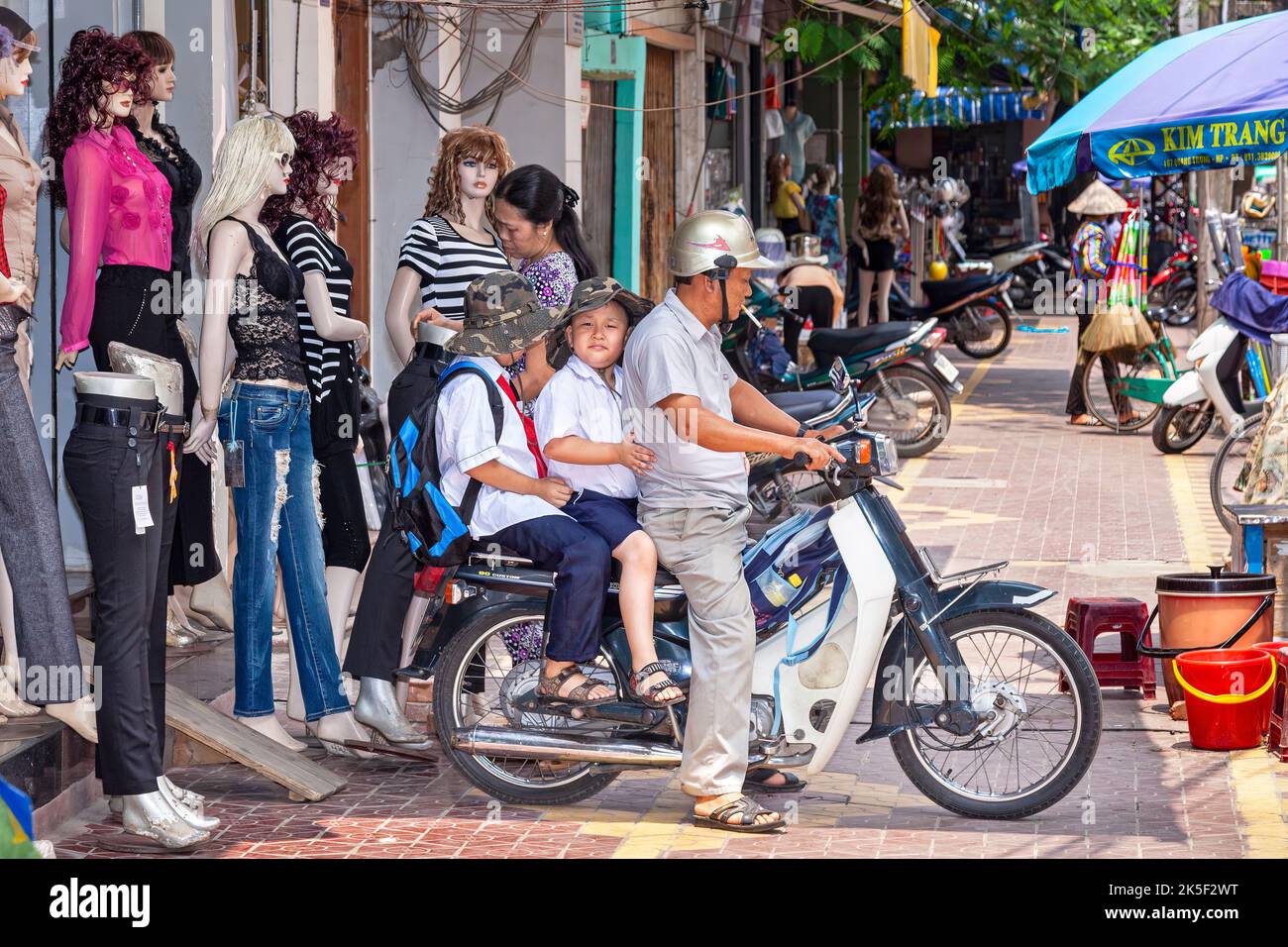 Family on motorcycle in busy street, Hai Phong, Vietnam Stock Photo