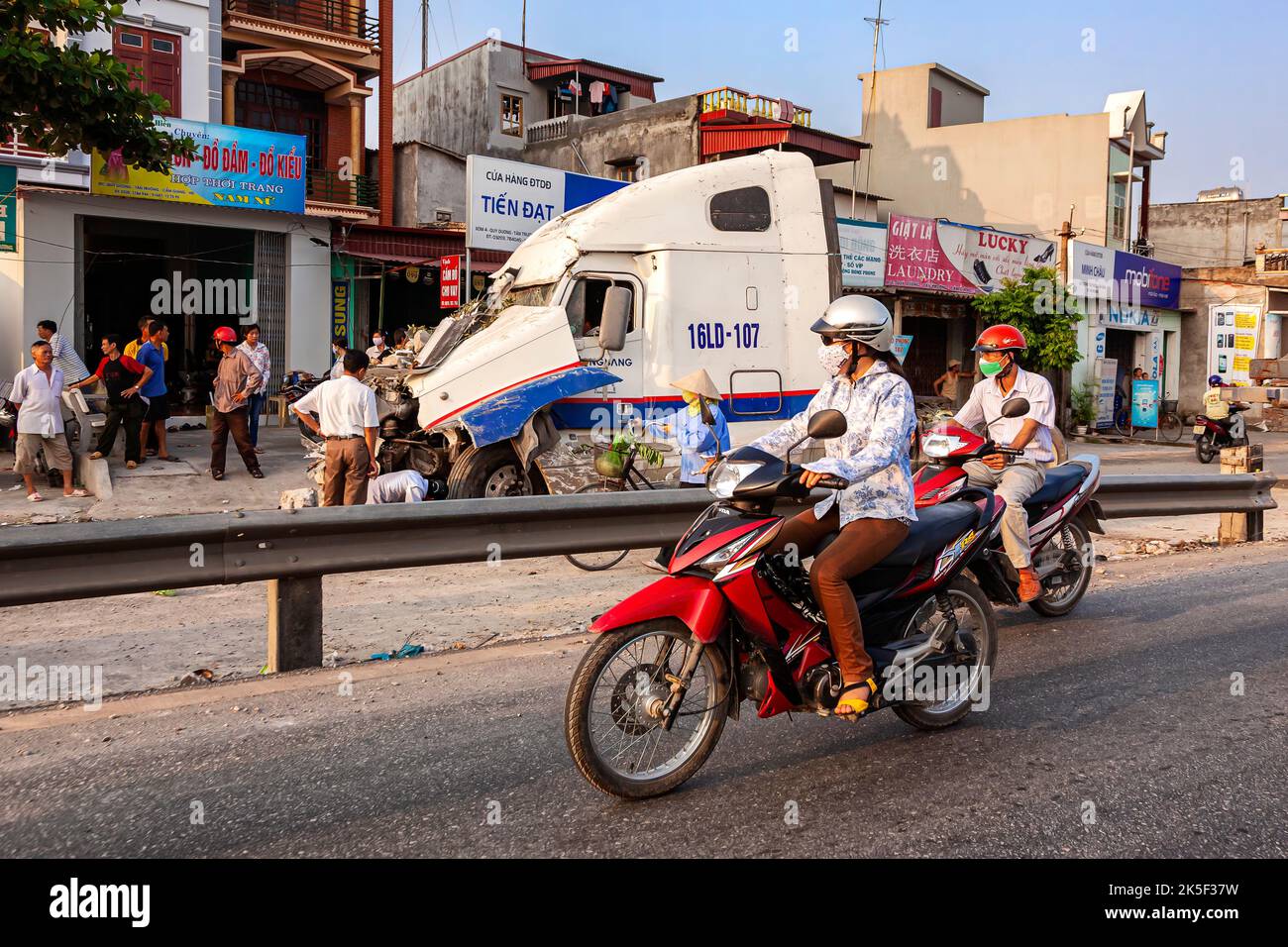 Motorcycle passing truck accident on service road on Hai Phong to Hanoi road, Vietnam Stock Photo