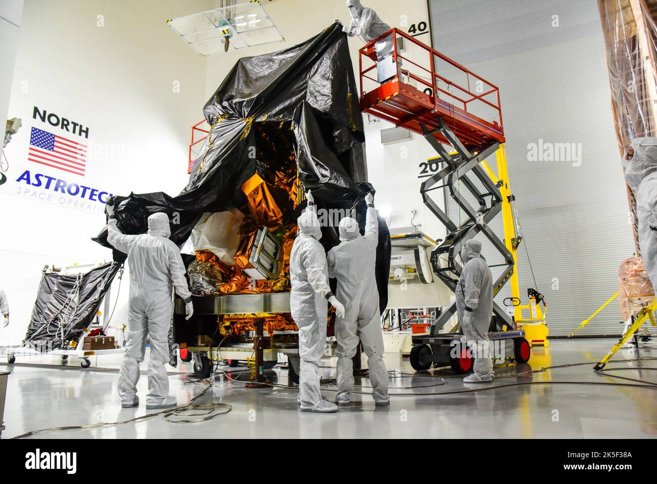 Technicians remove the protective covering from NASA and the National Oceanic and Atmospheric Administration’s (NOAA) Joint Polar Satellite System-2 (JPSS-2) satellite inside the Astrotech Space Operations facility at Vandenberg Space Force Base in California on Aug. 22, 2022. JPSS-2 is the third satellite in the Joint Polar Satellite System series. It is scheduled to lift off from VSFB on Nov. 1 from Space Launch Complex-3. JPSS-2, which will be renamed NOAA-21 after reaching orbit, will join a constellation of JPSS satellites that orbit from the North to the South pole, circling Earth 14 tim Stock Photo