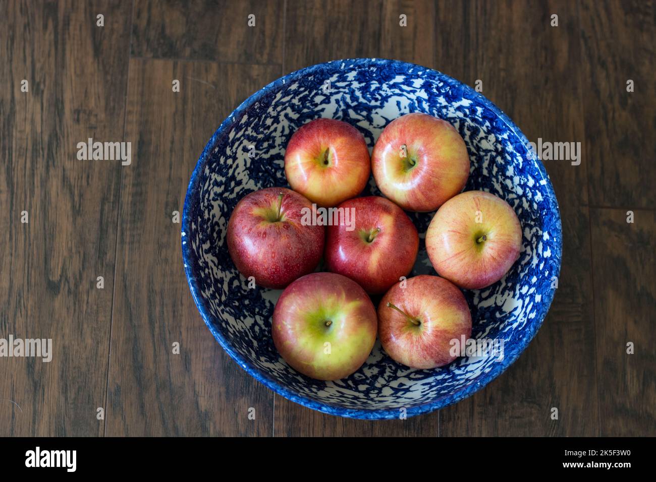 a blue bowl filled with red apples Stock Photo