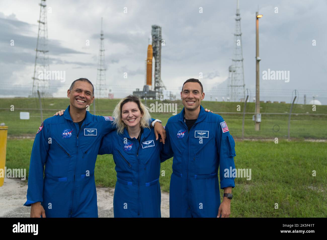From left to right, NASA astronaut candidates Anil Menon, Deniz Burnham, and Marcos Berrios pose for a photograph in front of NASA’s Artemis I Space Launch System and Orion spacecraft atop the mobile launcher on the pad at Launch Complex 39B at the agency’s Kennedy Space Center in Florida on Sept. 2, 2022. The first in a series of increasingly complex missions, Artemis I will provide a foundation for human deep space exploration and demonstrate our commitment and capability to extend human presence to the Moon and beyond. The primary goal of Artemis I is to thoroughly test the integrated syste Stock Photo