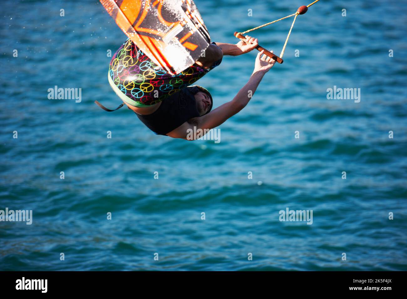 A young man wearing a helmut and lifejacket wakeboarding on a lake Stock Photo