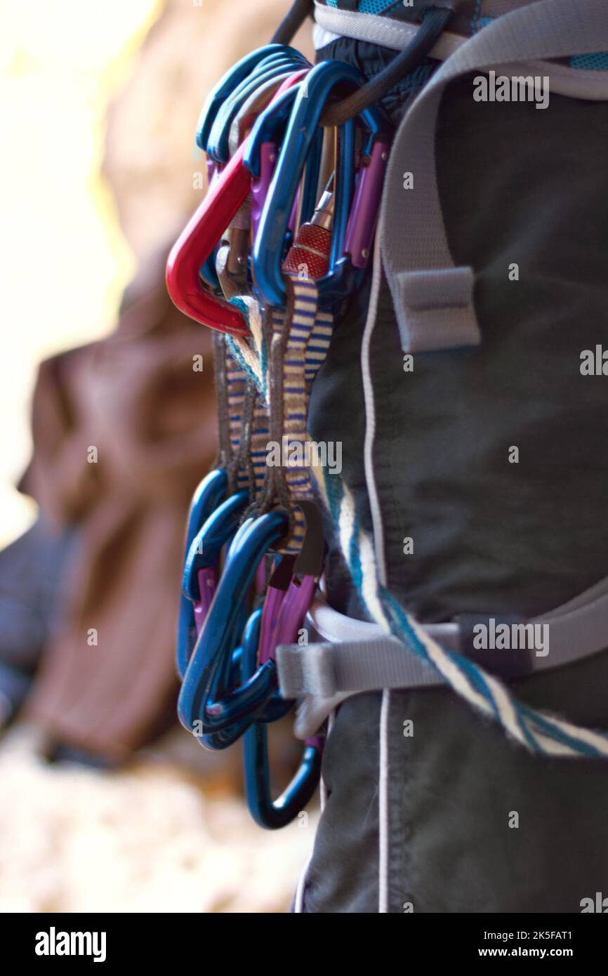 Shes ready to make the climb. the ccarabiners attached to a female rock climber. Stock Photo