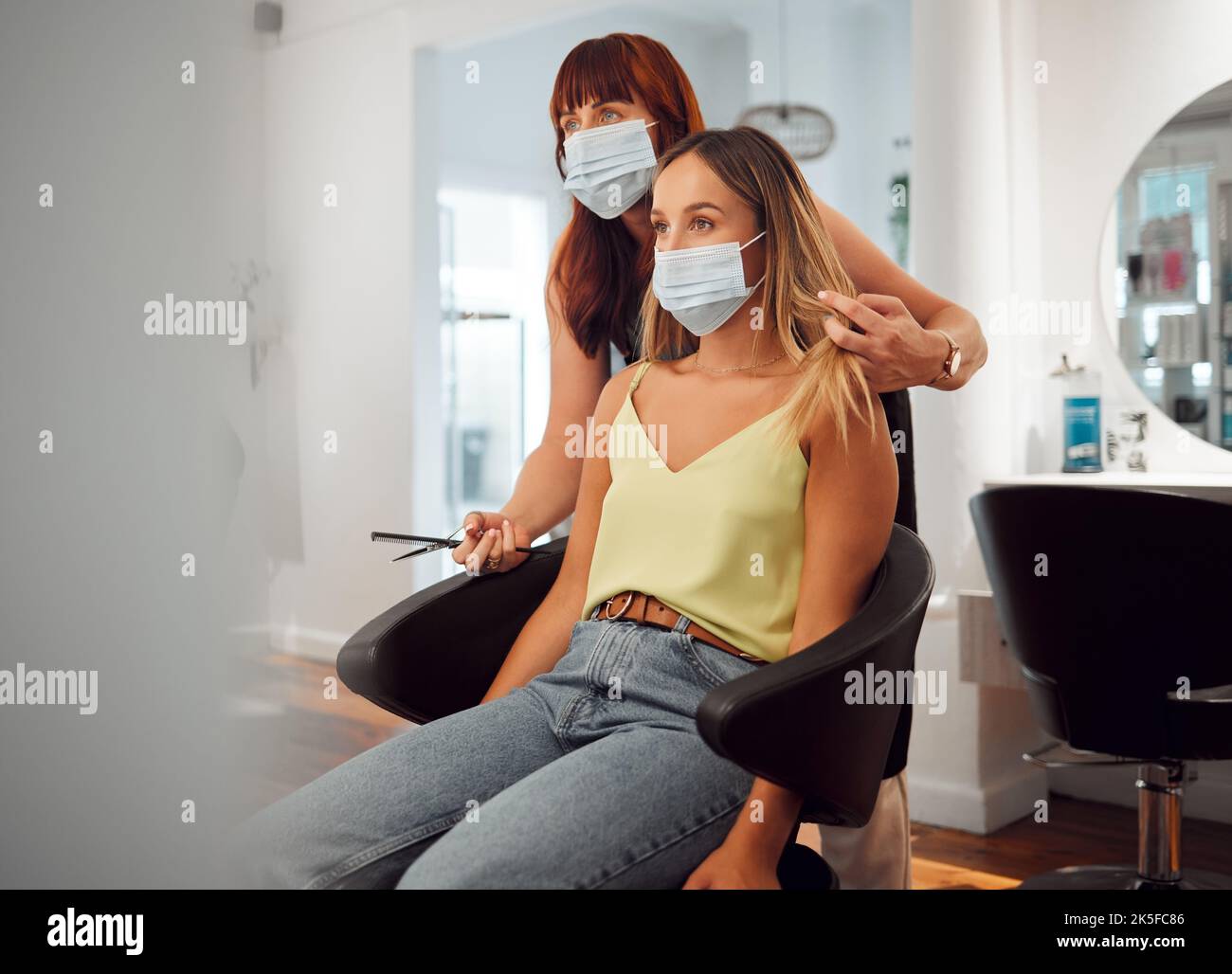 Covid, hairdresser and woman in hair salon getting haircut looking in mirror. Hairdressing, hair care and beauty business in covid 19 crisis. Woman Stock Photo