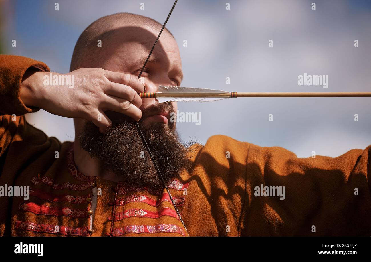 Medieval archery tournament. Man shoots an arrow in the medieval castle
